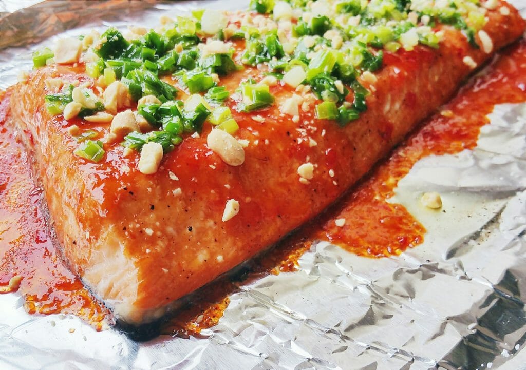 Thai style sweet chili grilled salmon with Mae Ploy sauce and topped with scallion oil