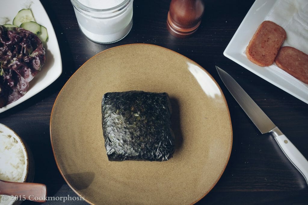 spam and egg onigirazu wrapped nicely in seaweed and placed on a large plate