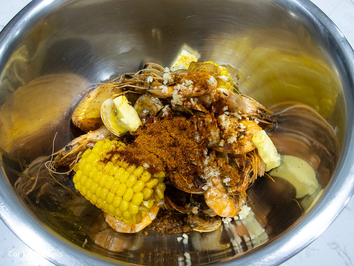 melted butter, minced garlic, and Cajun mix are added into seafood bowl