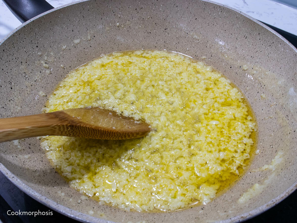 stirring minced garlic in melted butter