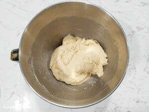 cinnamon raisin bread enriched dough after mixing then resting in the mixing bowl