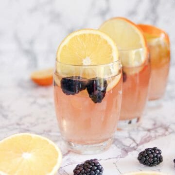 easy vodka mixed drink garnished with blackberries and oranges slices