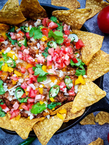 easy cheesy beef nachos recipe made with ground beef, chopped tomatoes, cilantro leaves and jalapeno