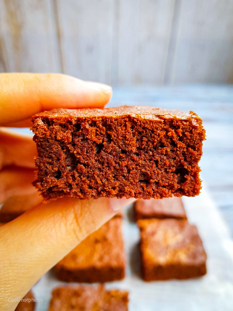 easy fudgy brownies are hold up by a hand