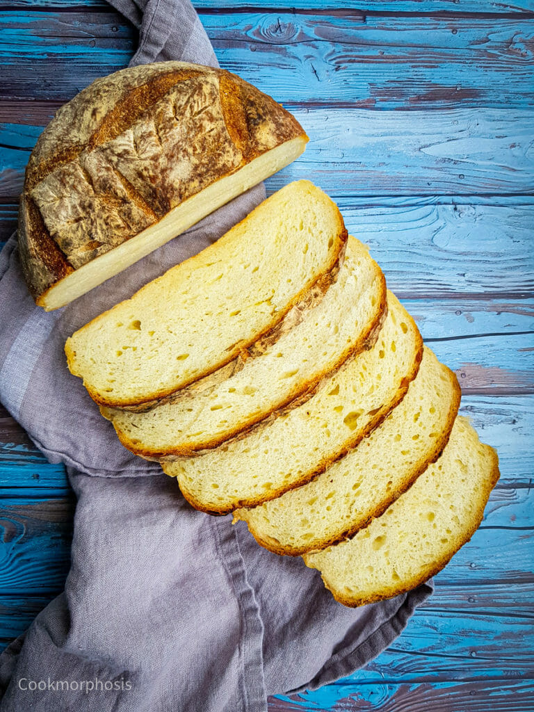 homemade artisan cheese bread with 5 slices of bread put on a grey kitchen towel