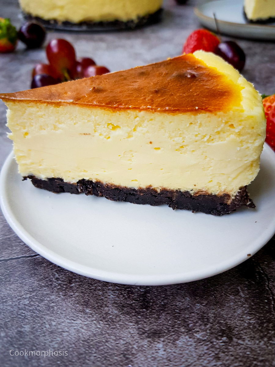 homemade creamy cheesecake with oreo crust and grapes placed on the background