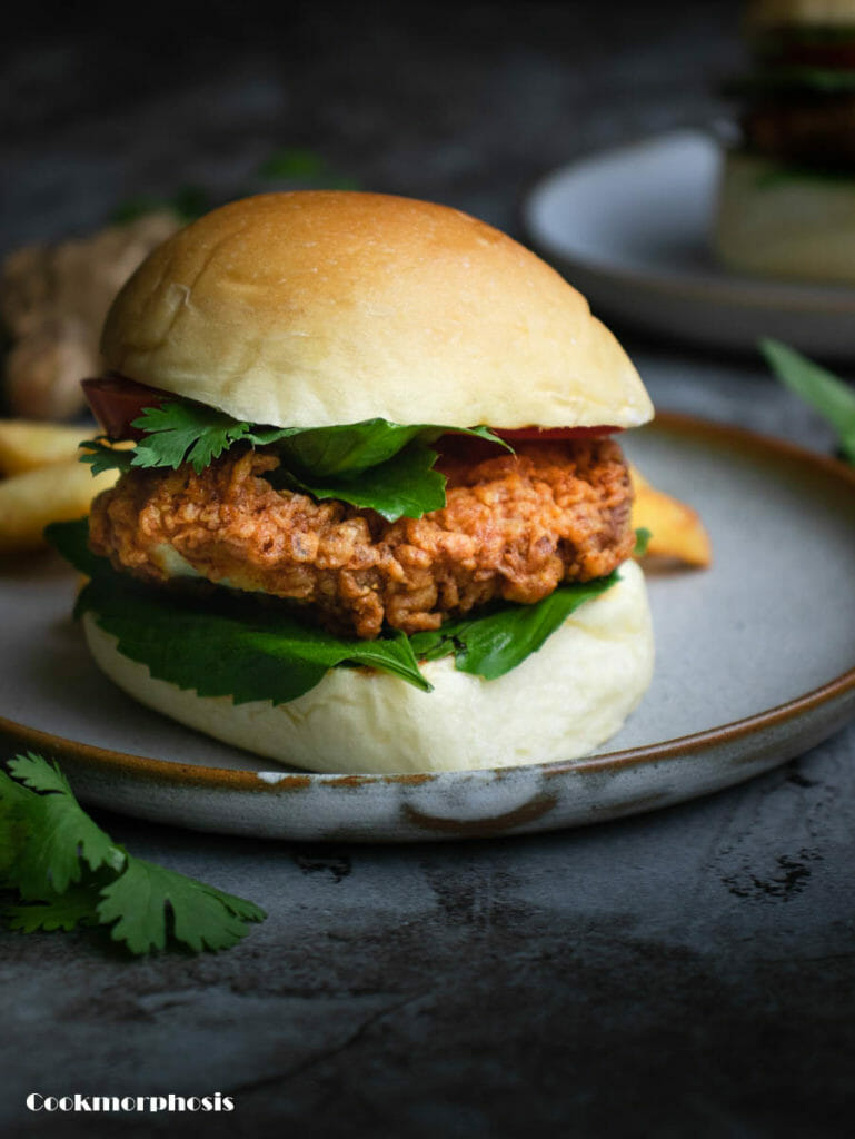 vietnamese fusion food recipe: buns, crispy fried chicken, assorted asian herbs and a piece of tomato