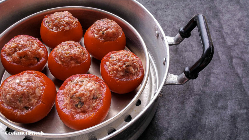 7 uncooked stuffed tomatoes put inside a steamer