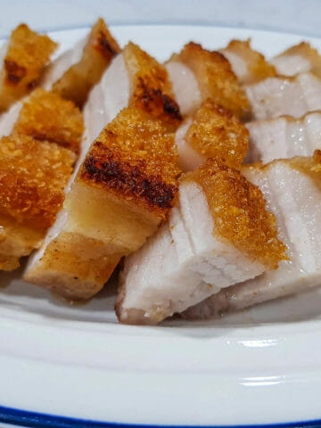 Asian crispy pork belly cut into pieces and put on white plate