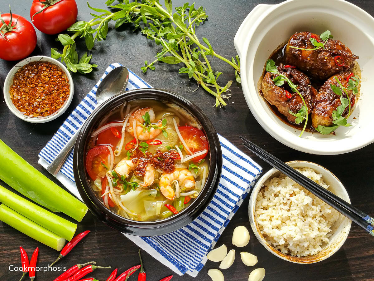 classic vietnamese soup canh chua tom is served with a bowl of steamed rice and catfish clay pot