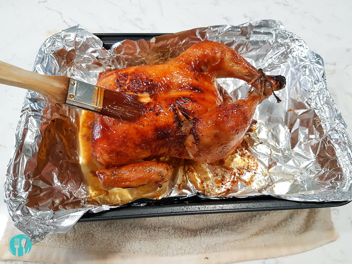 basting chicken with sweet and spicy BBQ sauce