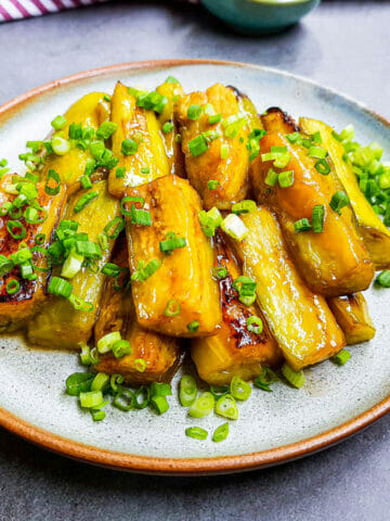 a plate of stir-fried eggplants with sweet miso sauce and garnished with green onion