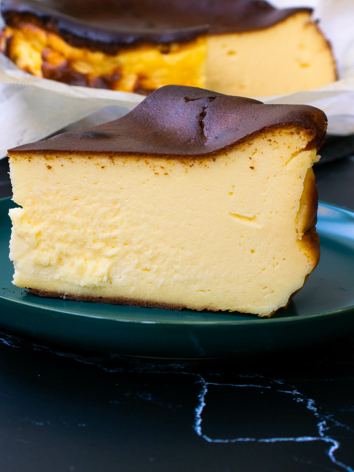 a slice of basque burnt cheesecake put on a green plate