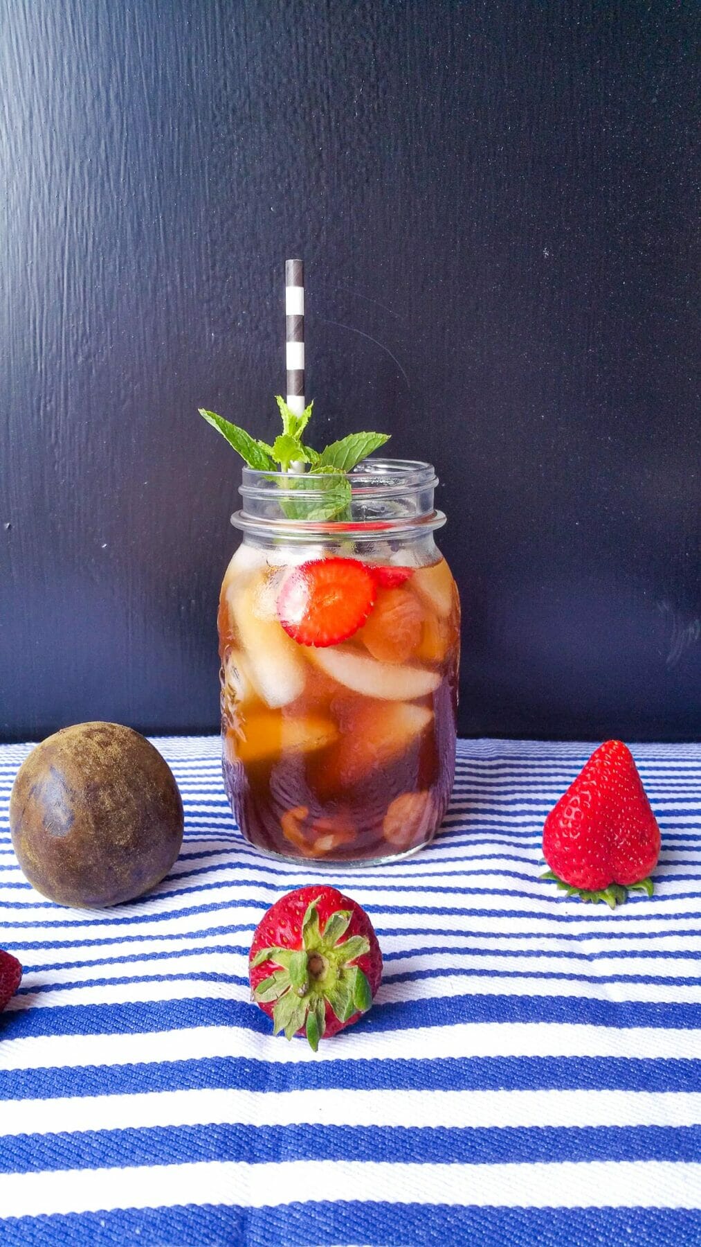 a mug of nuoc sam put next to a dried monk fruit and 2 fresh strawberries