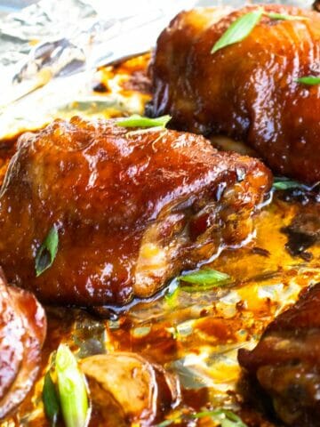 a piece of oven baked soy sauce chicken thigh garnished with green onion