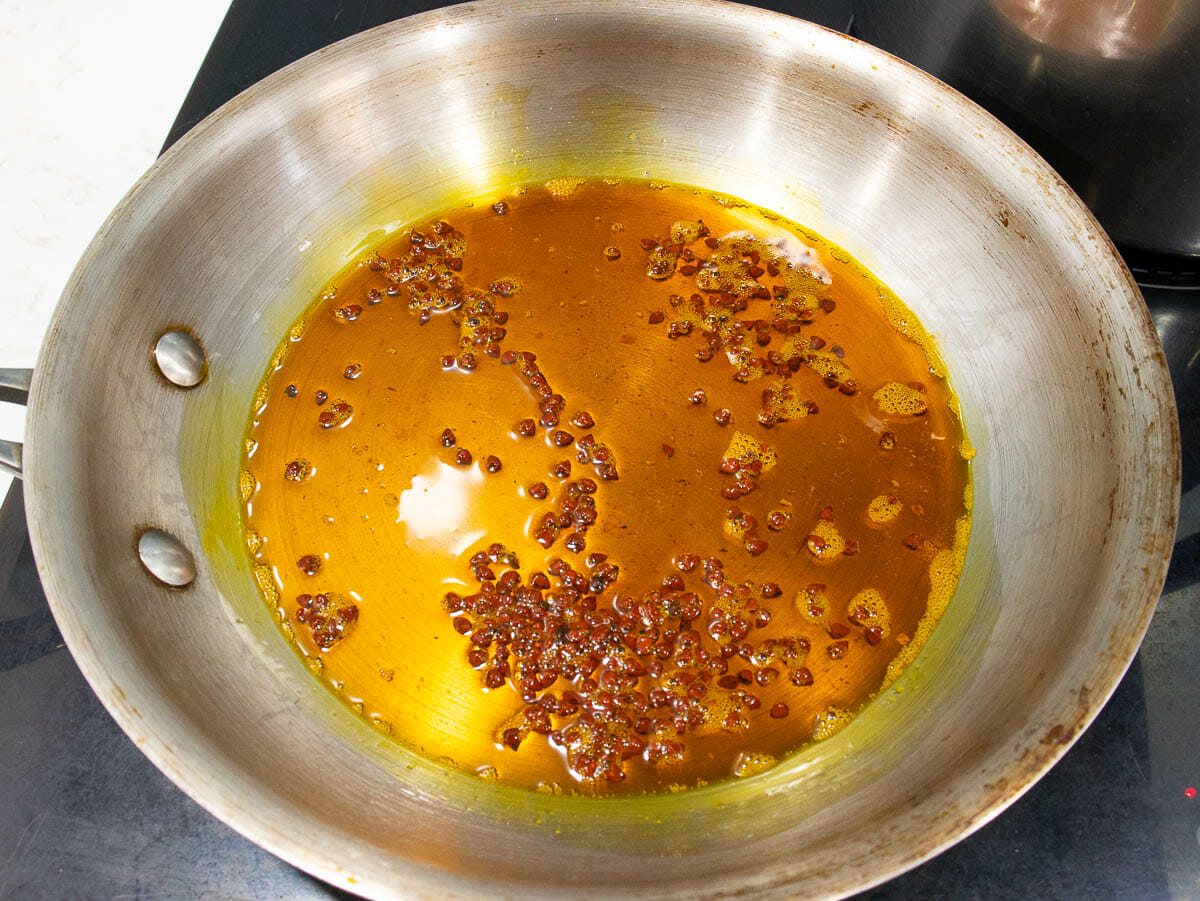 cook annatto seeds with sesame oil in a stainless steel pan