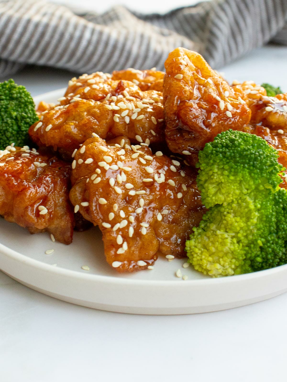 4 chicken nuggets topped with white sesame seeds and served with steamed broccoli