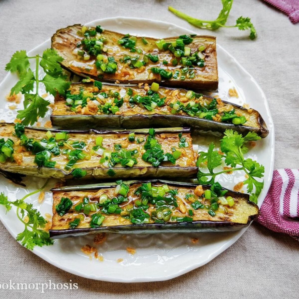 4 halves of grilled eggplants topped with green onion oil and cilantro