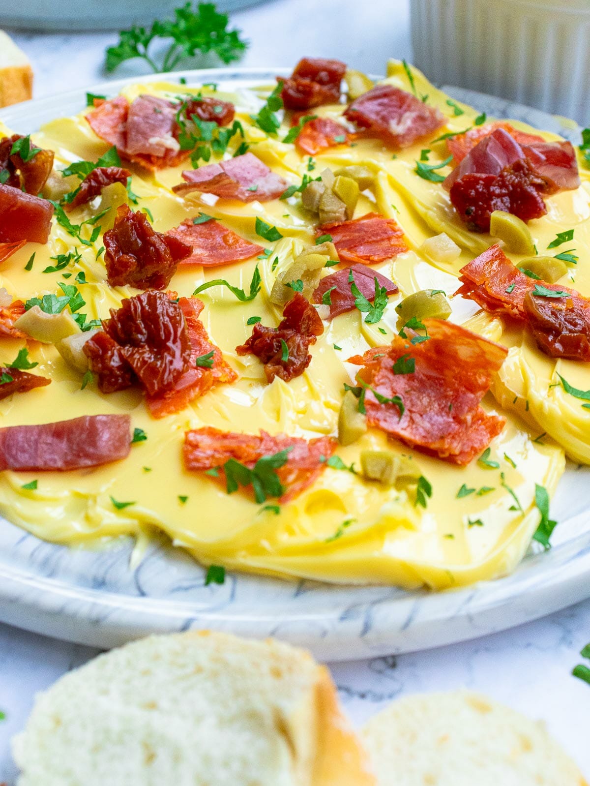 Gros plan sur une planche à beurre facile et rapide garnie de salami, de coppa, de persil, d'olives et de tomates séchées au soleil.