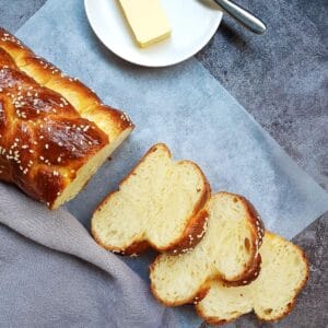 three slices of challah bread put next to a plate of unsalted butter