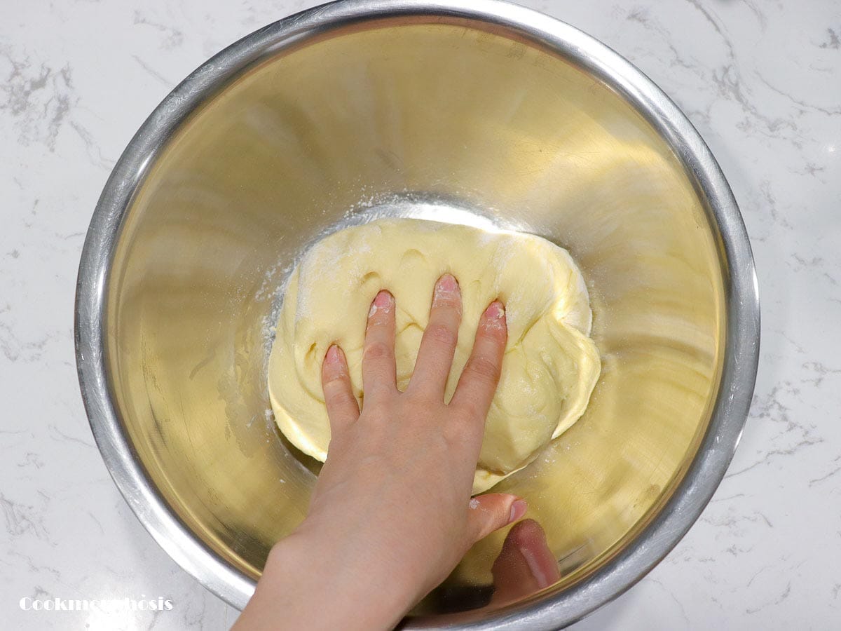 kneading dinner rolls dough with hand