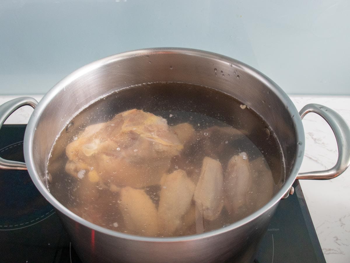 chicken bones are covered with cold water in a large stock pot