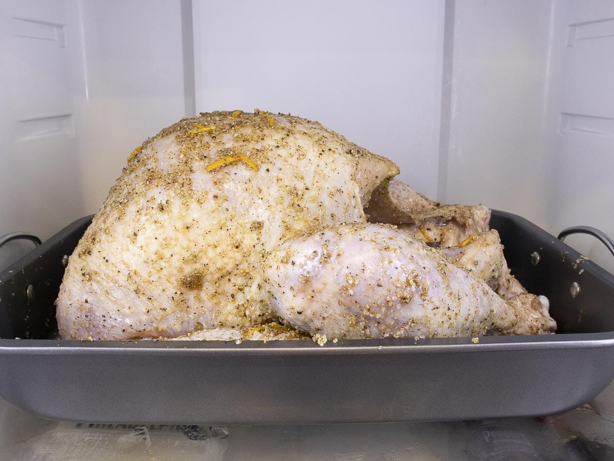 a turkey is cover in dry brine spices and put in the fridge