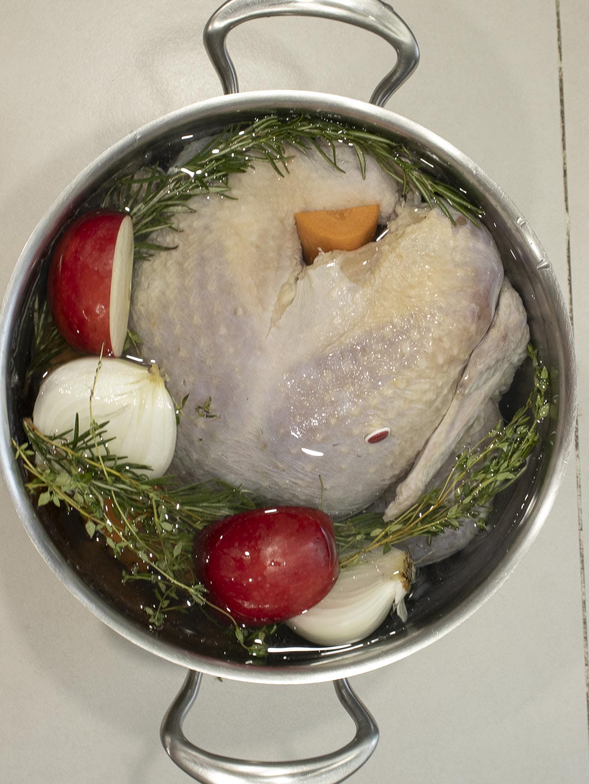 Brine a turkey in a big soup pot with apple, rosemary, thyme