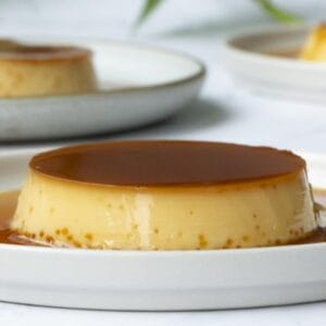 a close up of a creamy condensed milk flan put on a white plate