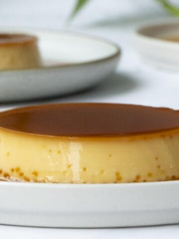 a close up of a creamy condensed milk flan put on a white plate