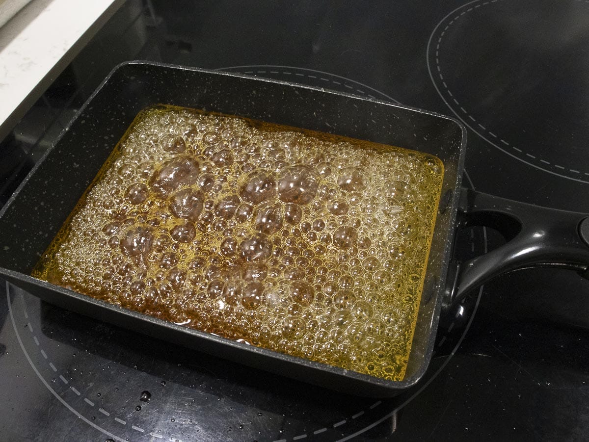 a pan of caramel sauce has a deep golden brown color