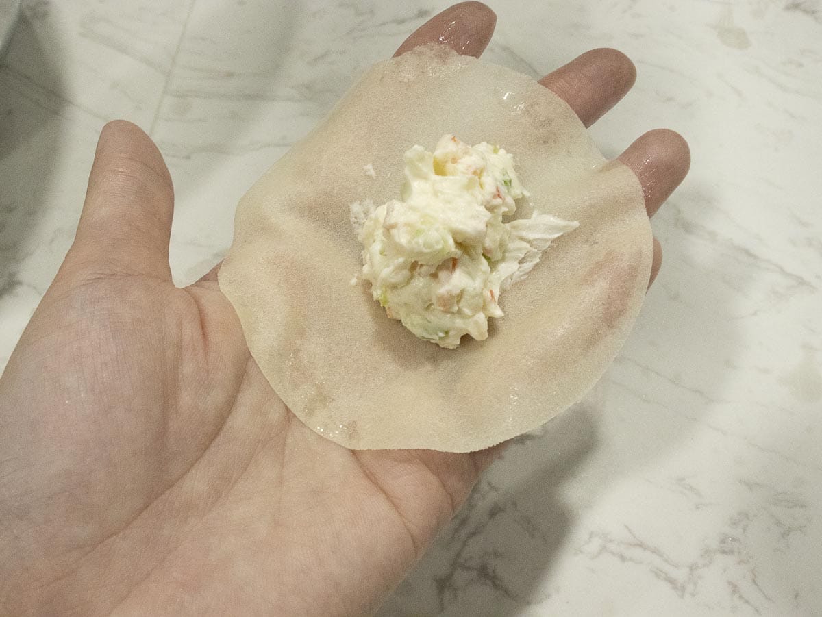 wrapping a crab rangoon using hands