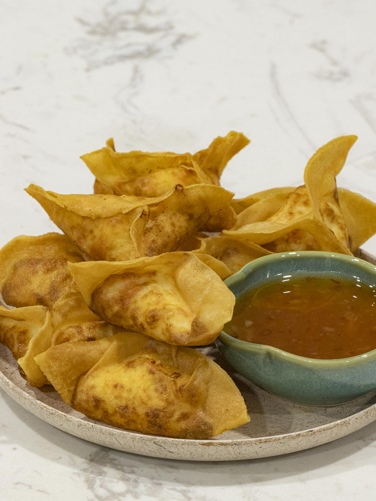 a plate of cream cheese filled crab rangoons